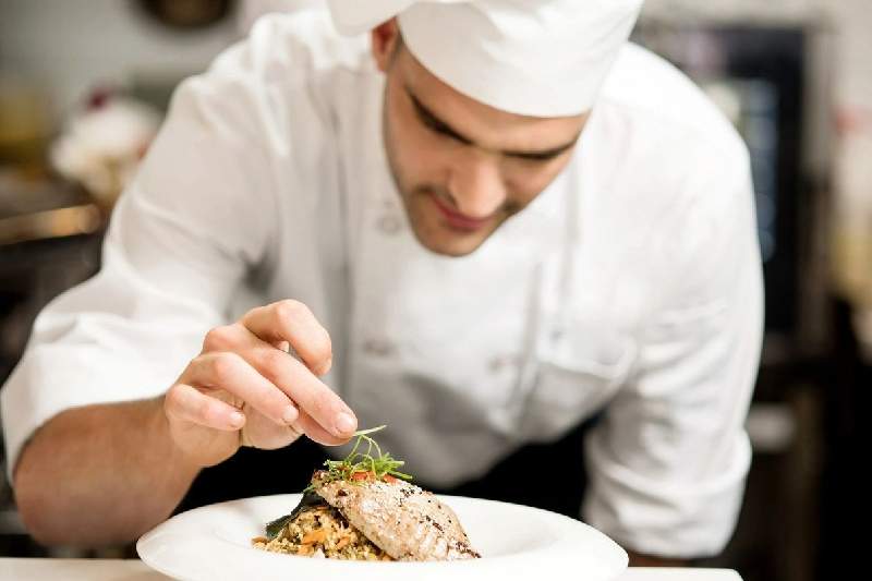 A chef is preparing food on top of a plate.